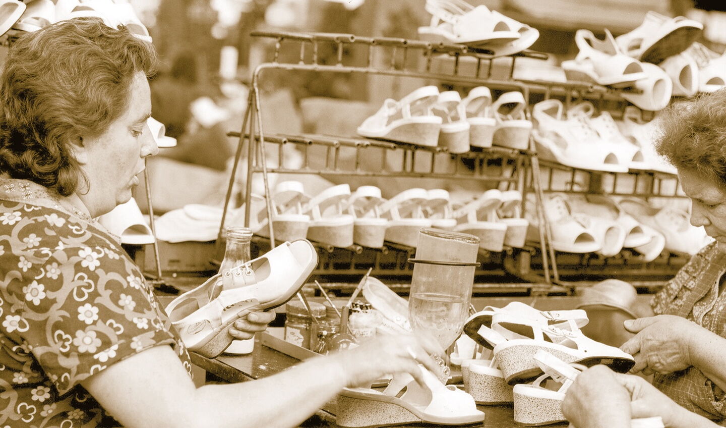 zwei Frauen arbeiten an weißen Sandalen